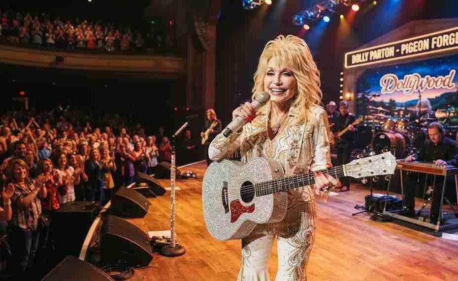 Dolly Parton performing live on stage with a sparkling rhinestone guitar in front of an enthusiastic audience.